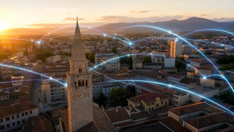 Skyline di Pordenone con linee di fibra ottica che collegano gli edifici aziendali